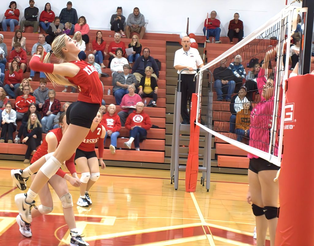 Harper Richardson soars high above the net to smash a kill during Marshall's huge three-set comeback win over Lawrenceville. Photo by T Ray Henry.